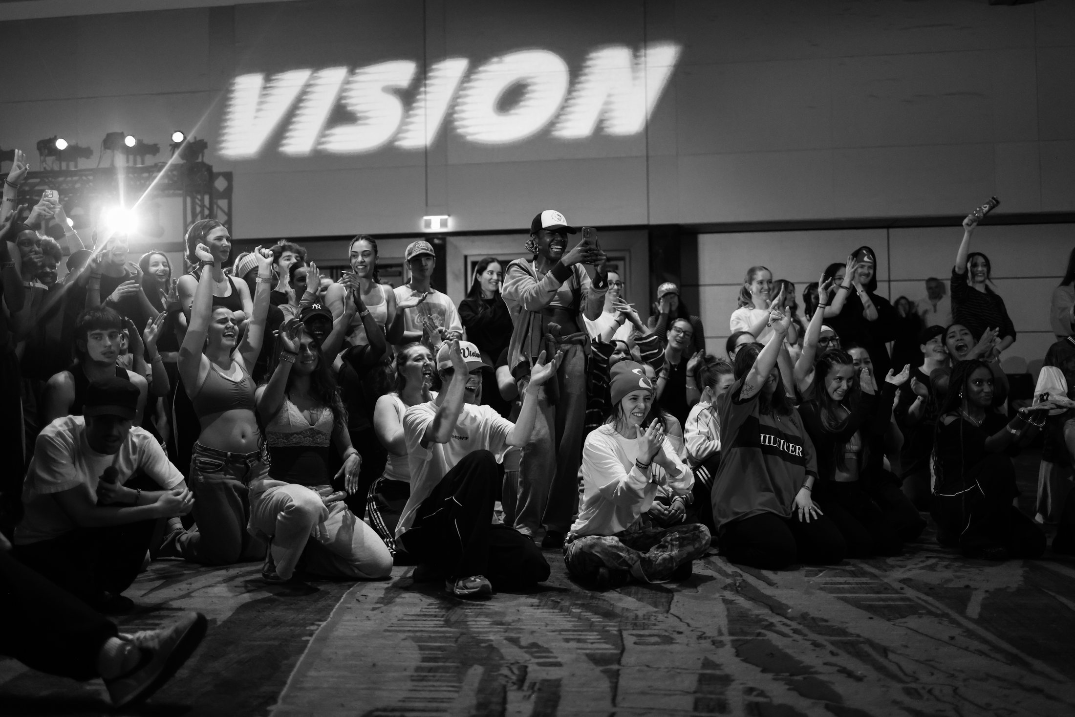 Black and white crowd scene highlighting strong logo visibility across a live VISION moment.